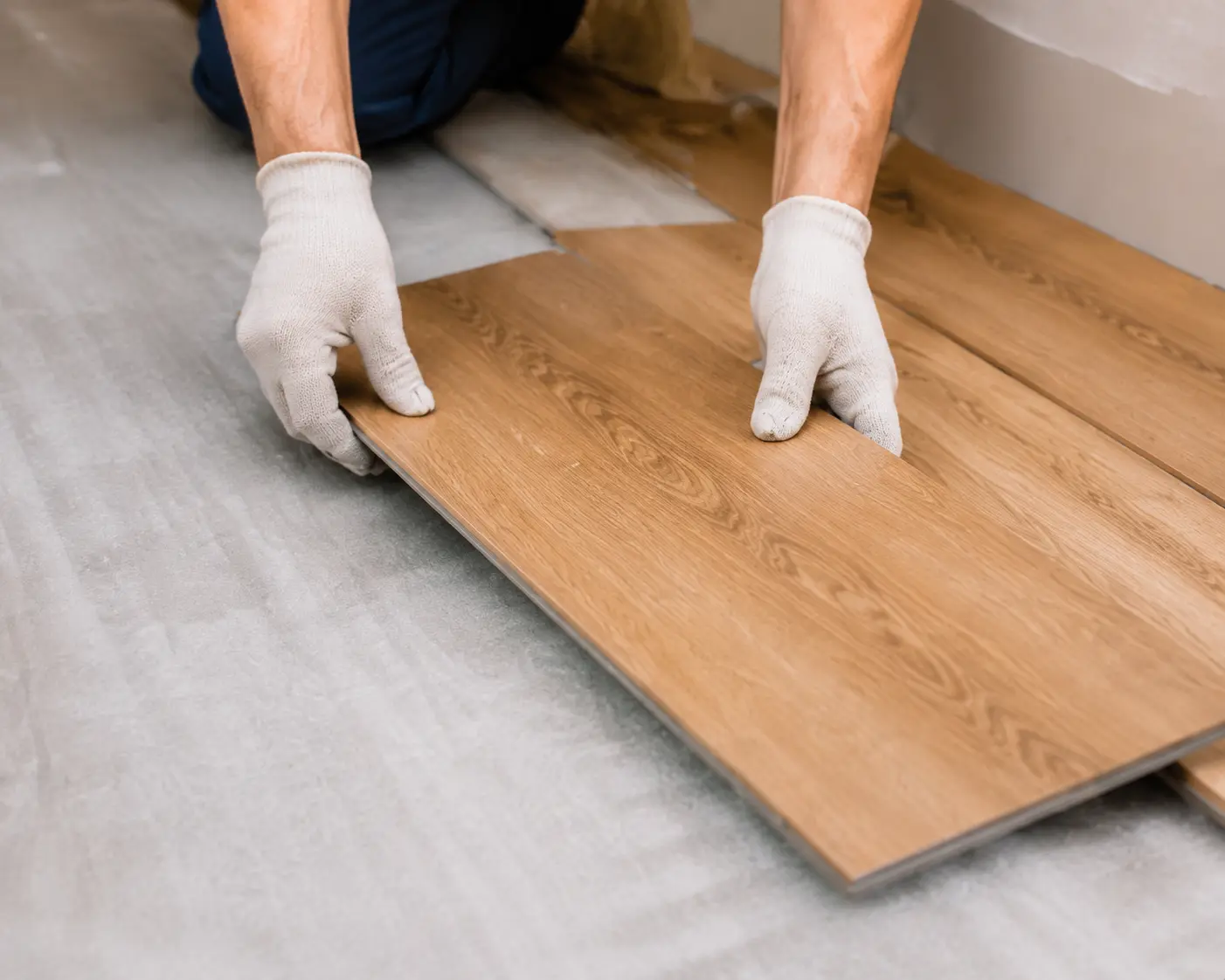 Installing flooring image showing wood laminate planks being fitted on a subfloor for estimating flooring materials, coverage, and installation requirements with a flooring calculator